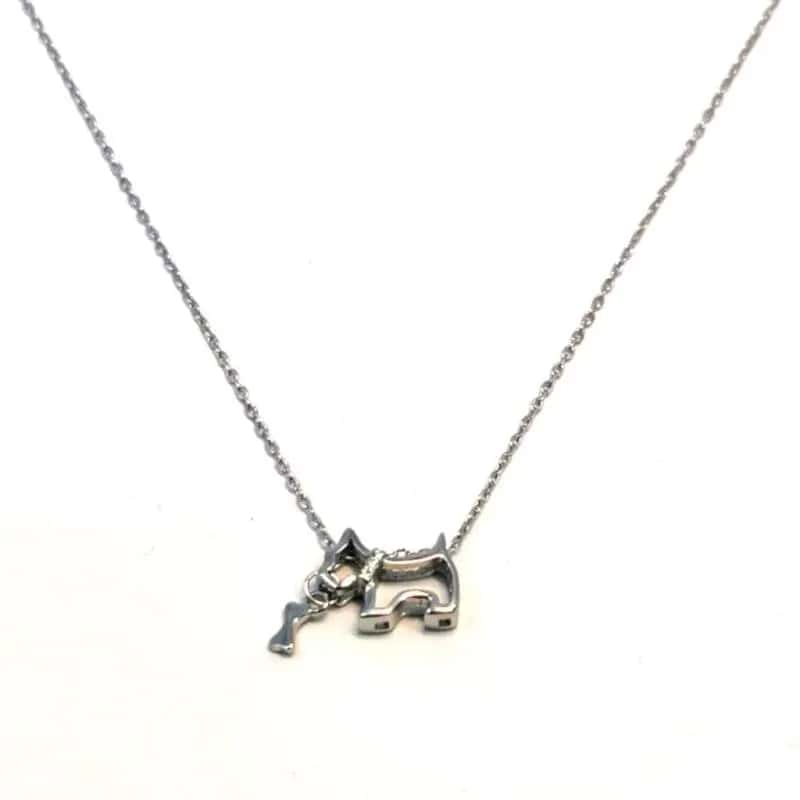 Collar de plata con colgante de perro juguetón con piedras blancas y un hueso en la boca